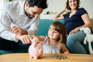 Family putting money into piggy bank